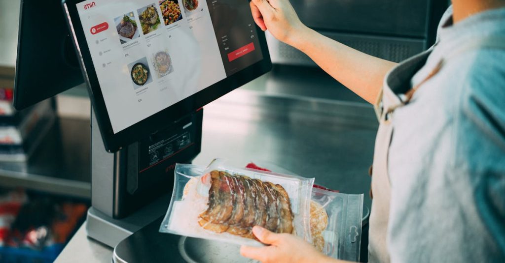 Person using digital POS system in a restaurant for cashless food payment.